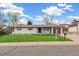 Charming single-story home with a well-manicured lawn, mature trees, and a welcoming entrance at 8622 W Warren Ln, Lakewood, CO 80227