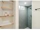 Basement shower with built in shelves, gray subway tile, a rainfall shower head, and hexagonal floor tiles at 8622 W Warren Ln, Lakewood, CO 80227
