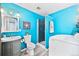 Stylish bathroom with blue walls, a glass-enclosed shower, modern fixtures, and a convenient washer, creating a spa-like retreat at 5602 S Yank Ct, Littleton, CO 80127