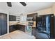 Updated kitchen with dark cabinets, stainless steel appliances, tile backsplash, and wood-look tile floors at 5602 S Yank Ct, Littleton, CO 80127
