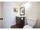 Well-lit half bathroom featuring a wooden vanity, granite countertop, and modern fixtures at 6275 Lakewood Rd, Parker, CO 80134