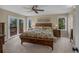 Bright bedroom featuring plush carpet and doors leading to a private deck overlooking nature at 6275 Lakewood Rd, Parker, CO 80134