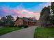 Stunning exterior elevation of home with a beautiful driveway and colorful sunset backdrop at 6275 Lakewood Rd, Parker, CO 80134