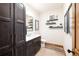 Stylish bathroom featuring dark wood cabinets, marble countertop, floating shelves, and wood-look floors at 186 Rachel Ln, Breckenridge, CO 80424