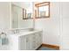 Bright bathroom featuring double sinks, white cabinets, marble countertops, and wood trim windows at 186 Rachel Ln, Breckenridge, CO 80424