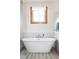 Bright bathroom featuring a white soaker tub under a window with natural wood trim at 186 Rachel Ln, Breckenridge, CO 80424