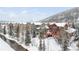 Aerial view of townhomes in winter with snow-covered trees and river at 186 Rachel Ln, Breckenridge, CO 80424
