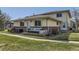 Charming exterior view of home with yellow siding, brick accents, and a cozy front porch with stylish outdoor seating at 3225 S Garrison St # 9, Lakewood, CO 80227