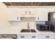 Updated kitchen boasts stainless steel sink, white cabinets and countertop, with modern microwave at 3225 S Garrison St # 9, Lakewood, CO 80227