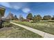 Expansive green lawn with mature trees and a clear blue sky, offering a serene outdoor setting at 3225 S Garrison St # 9, Lakewood, CO 80227