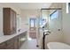 A stylish bathroom features a dual sink vanity, modern fixtures, glass shower and soaking tub for a spa-like experience at 5741 Doc Bar Circle, Larkspur, CO 80118