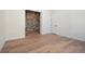 Empty bedroom featuring wood flooring, a brick accent wall, and a neutral color scheme at 5741 Doc Bar Circle, Larkspur, CO 80118