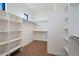 A well-organized walk-in closet features white shelving for clothing and accessory storage at 5741 Doc Bar Circle, Larkspur, CO 80118