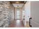 Inviting entryway featuring a brick accent wall, wood floors, and a front door with sidelights at 5741 Doc Bar Circle, Larkspur, CO 80118