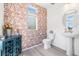 Stylish half bathroom with leaf wallpaper, updated vanity, and modern fixtures, creating a chic and inviting space at 16362 E 111Th Dr, Commerce City, CO 80022