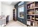 Charming office featuring a built-in bookcase, a desk, and patterned wallpaper accent wall at 16362 E 111Th Dr, Commerce City, CO 80022