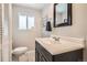 Cozy bathroom features a sink with cabinet, a mirror and window letting in natural light at 6431 W 77Th Pl, Arvada, CO 80003