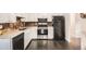 Well-appointed kitchen featuring white cabinets, stainless steel appliances, and dark wood flooring at 6431 W 77Th Pl, Arvada, CO 80003