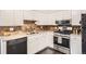 Modern kitchen featuring white cabinets, stainless steel appliances, and a brick backsplash at 6431 W 77Th Pl, Arvada, CO 80003