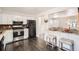 Modern kitchen featuring white cabinets, stainless steel appliances, and dark wood flooring at 6431 W 77Th Pl, Arvada, CO 80003