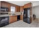 Efficient kitchen featuring tile flooring, sleek black appliances, and ample storage space at 9338 W Utah Pl, Lakewood, CO 80232