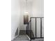 Carpeted staircase featuring contemporary metal railing and stylish light fixture at 9338 W Utah Pl, Lakewood, CO 80232