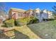 Backyard with a deck, shrubs, grass, and stone exterior of home at 14032 E Chenango Dr, Aurora, CO 80015