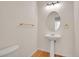 Bright powder room featuring a pedestal sink, oval mirror, and wood-look floors at 14032 E Chenango Dr, Aurora, CO 80015