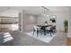 Bright dining room featuring modern lighting, stylish furnishings, and an adjacent view into a spacious kitchen at 14032 E Chenango Dr, Aurora, CO 80015