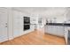 Open kitchen with white cabinets, stainless steel appliances and hardwood floors at 14032 E Chenango Dr, Aurora, CO 80015