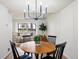 Dining area adjacent to living room, featuring a wooden table and modern light fixture at 10310 E Jewell Ave # 57, Aurora, CO 80247