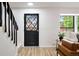 Home entryway with a black door, staircase, and hardwood flooring at 10310 E Jewell Ave # 57, Aurora, CO 80247
