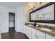 Bright bathroom featuring a double vanity with granite countertops and a large, framed mirror at 11262 Winona Ct, Westminster, CO 80031