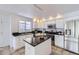 Well-lit kitchen featuring stainless steel appliances, island, and tile flooring at 11262 Winona Ct, Westminster, CO 80031