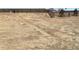 A graded, bare lot ready for new construction, partially enclosed by a wooden fence and marked with pink survey points at 11024 Snowdon St, Parker, CO 80134