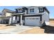 Beautiful home showcasing gray siding, white trim, a covered porch with stone accents, and a two-car garage on a sunny day at 11024 Snowdon St, Parker, CO 80134