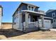Two-story home with a covered porch, stone supports, gray siding, white trim, and an attached two-car garage on a sunny day at 11024 Snowdon St, Parker, CO 80134
