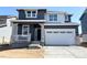 Charming two-story home featuring gray siding, white trim, stone accents, covered porch, and an attached two car garage at 11024 Snowdon St, Parker, CO 80134