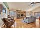 Living room with stone fireplace and hardwood floors, open to dining area at 1585 Old Antlers, Monument, CO 80132