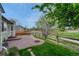 Charming backyard patio with brick pavers and fire pit overlooking a green space at 5350 S Quail Way, Littleton, CO 80127
