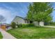 A cozy home with lush green lawn with mature trees on a sunny day at 5350 S Quail Way, Littleton, CO 80127