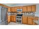 Kitchen features wood cabinets, granite countertops, stainless steel appliances, and tile floors at 5350 S Quail Way, Littleton, CO 80127