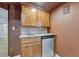 Wet bar area featuring cabinets, countertop, sink, tile backsplash, and mini-refrigerator at 5350 S Quail Way, Littleton, CO 80127