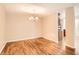 The dining room has sleek laminate floors, neutral paint, and bright lighting with an updated chandelier at 350 S Clinton St # 9B, Denver, CO 80247