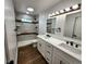 Modern bathroom with dual vanities, decorative mirrors, and updated shower with a glass enclosure at 16800 E Bails Pl, Aurora, CO 80017