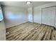 This bedroom showcases neutral walls, wood-look flooring, and a double door closet at 16800 E Bails Pl, Aurora, CO 80017