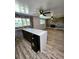 Open living room with a modern wet bar, stone fireplace, and wood-look floors at 16800 E Bails Pl, Aurora, CO 80017