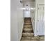 Bright stairway featuring modern wood-look floors and a white handrail leading to an upper level at 16800 E Bails Pl, Aurora, CO 80017