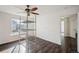 Sunlit bedroom with hardwood floors features a ceiling fan and large window; ready for personalized decor at 5202 Cathay St, Denver, CO 80249