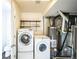 Functional laundry room featuring a modern washer and dryer, utility sink, and efficient water heater setup at 5202 Cathay St, Denver, CO 80249